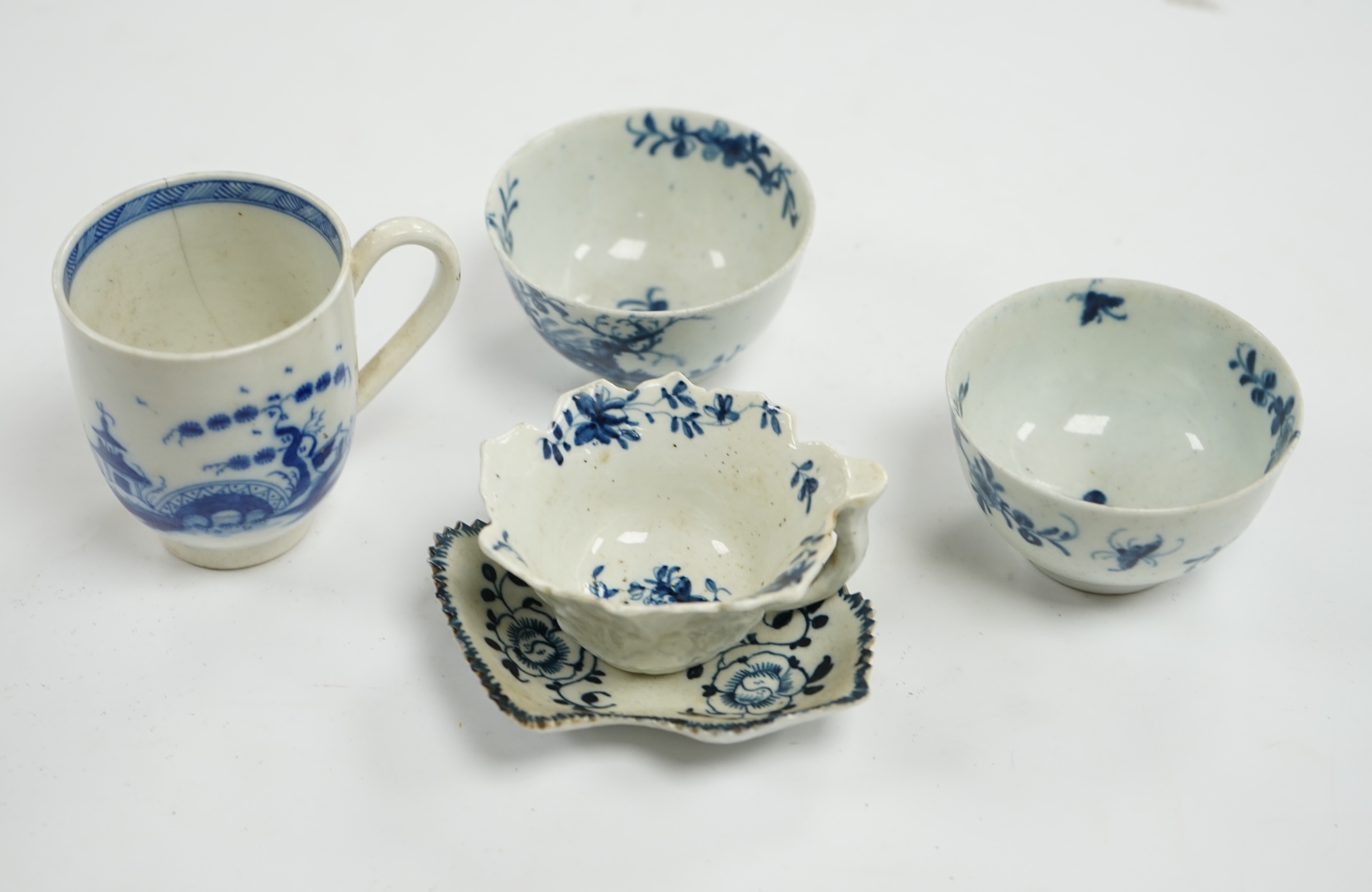 A group of first period blue and white Worcester, including a leaf cup and saucer, two tea bowls and a handled cup, leaf saucer 9.5cm wide (5). Condition - leaf cup cracked, two tea bowls good handled cup, bowl cracked